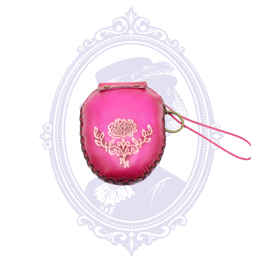 Back view of pink leather sugar skull coin purse featuring an embossed rose motif and wrist strap.