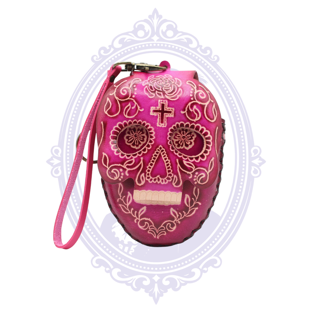 Pink leather sugar skull coin purse with decorative floral skull design and detachable wrist strap.