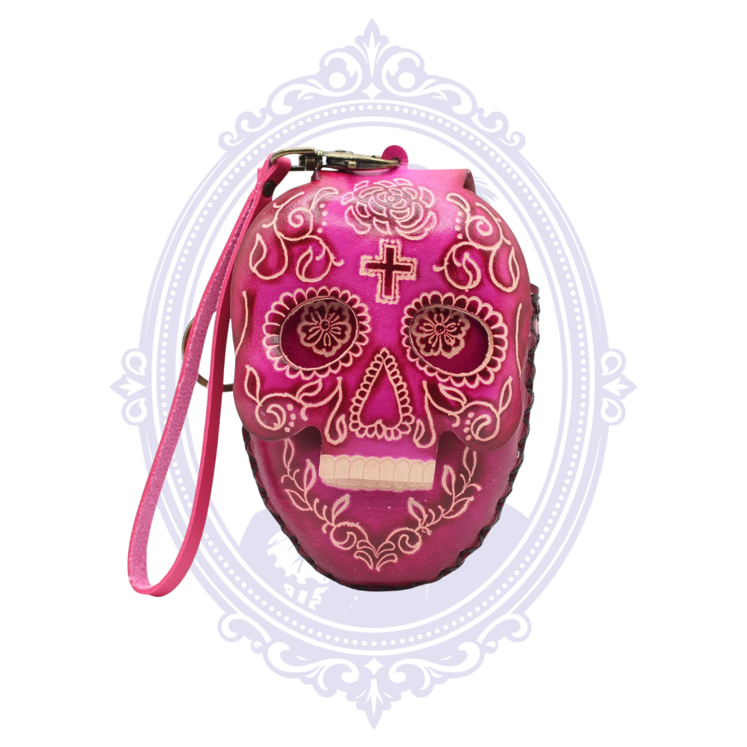 Pink leather sugar skull coin purse with decorative floral skull design and detachable wrist strap.