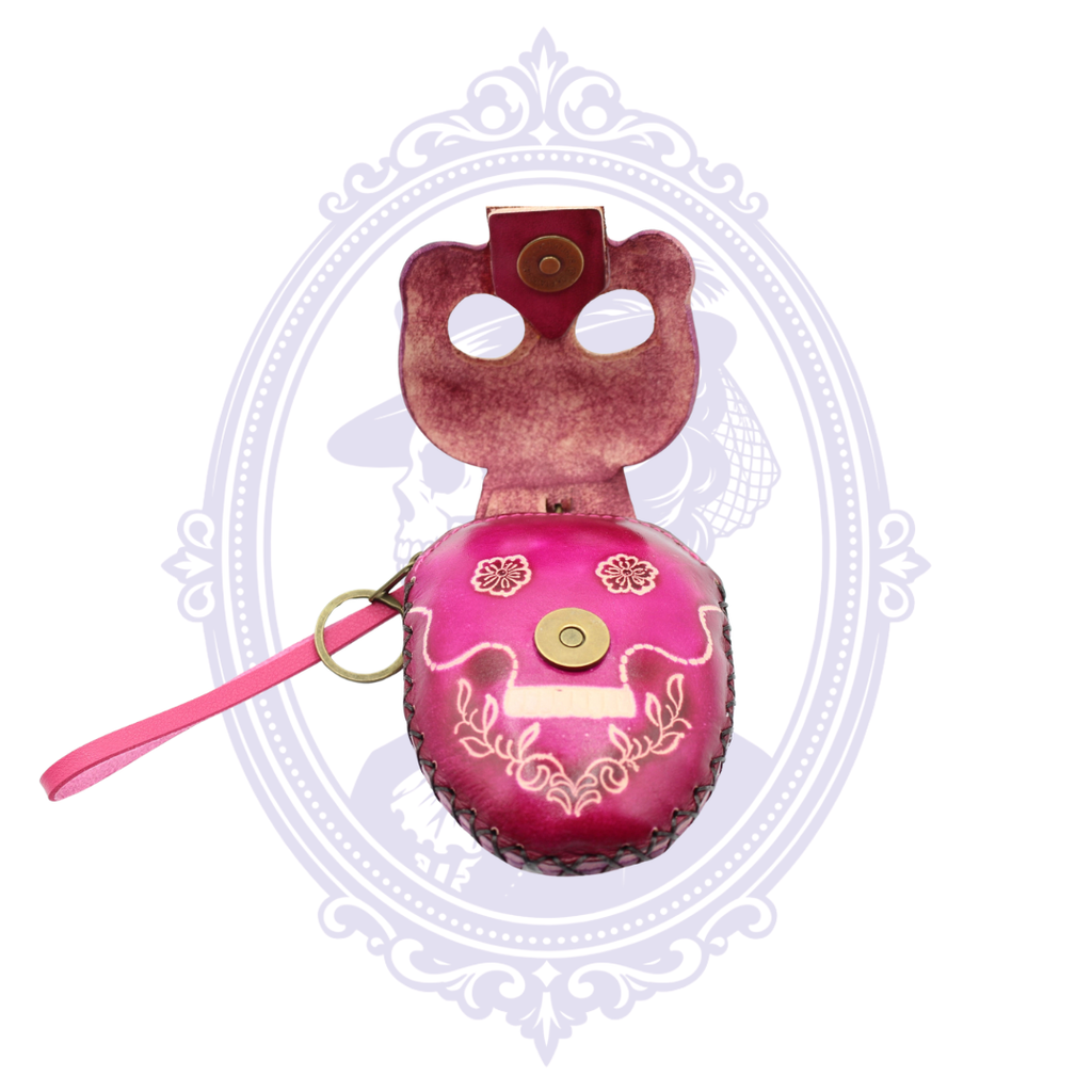 Pink leather sugar skull coin purse opened to show the decorative skull flap and magnetic snap closure.