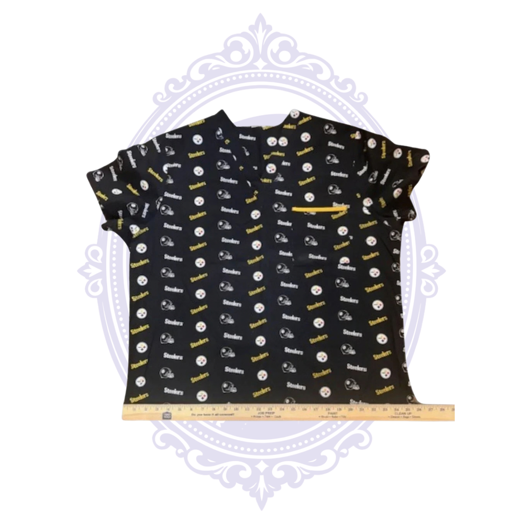 Pittsburgh Steelers black NFL logo print scrub top shown flat with ruler across the bottom hem for width measurement.