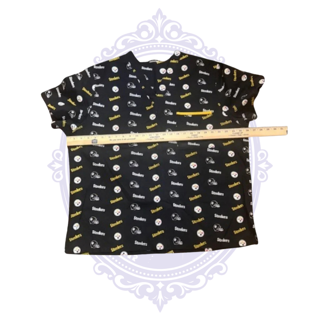 Pittsburgh Steelers black and gold women’s scrub top shown with ruler across the chest for width measurement.