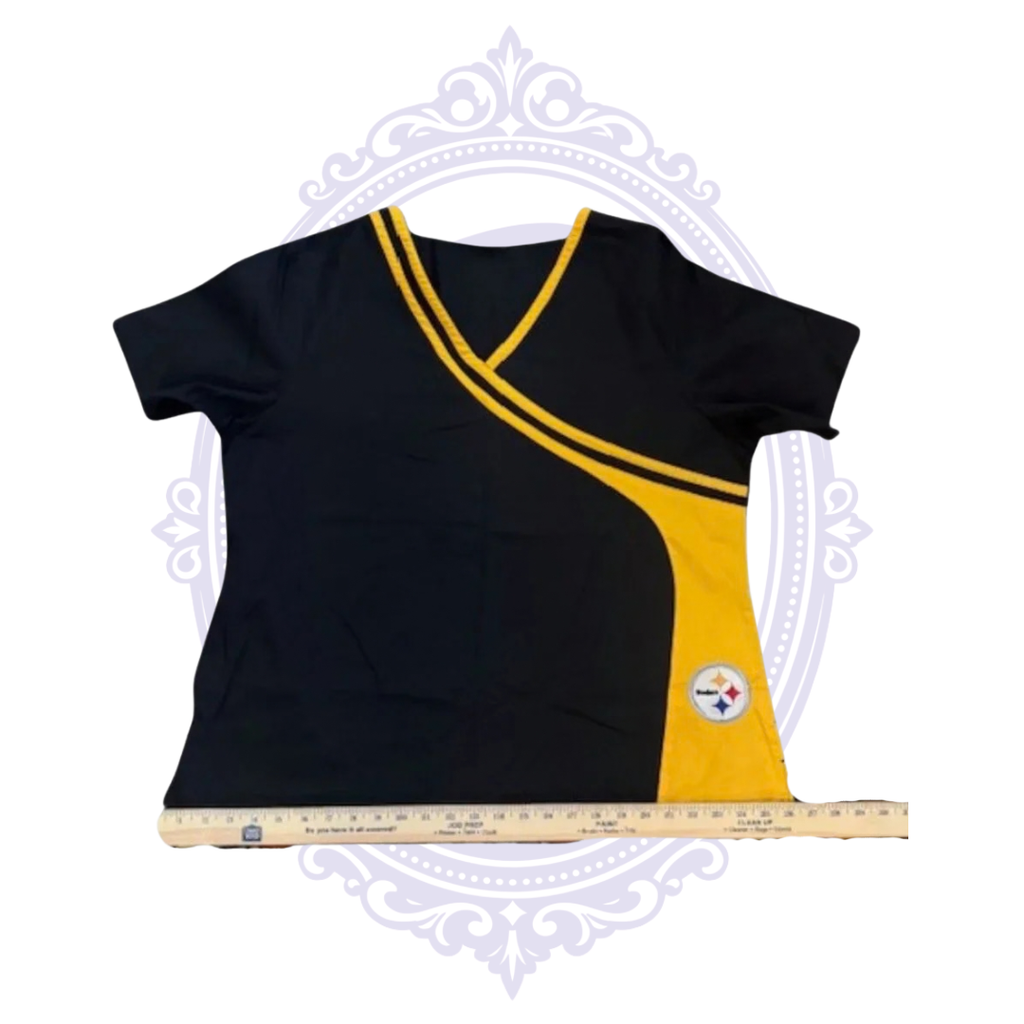 Pittsburgh Steelers black and gold scrub top laid flat with ruler across the bottom hem.