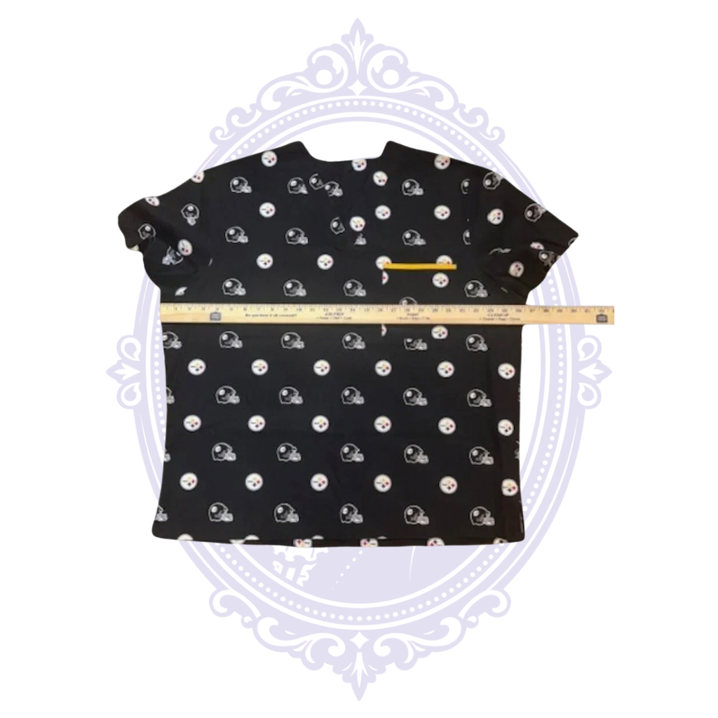 Pittsburgh Steelers black scrub top shown with ruler across the chest for width measurement.