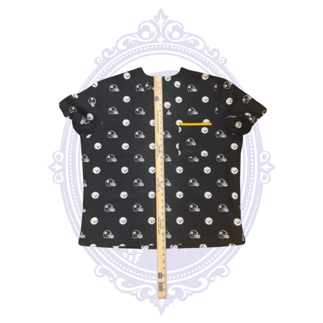Pittsburgh Steelers black scrub top with helmet and team logo print shown with ruler measuring garment length.