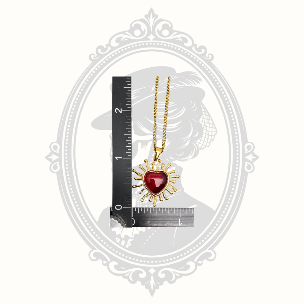 Radiant red heart pendant necklace shown beside a ruler for size reference.