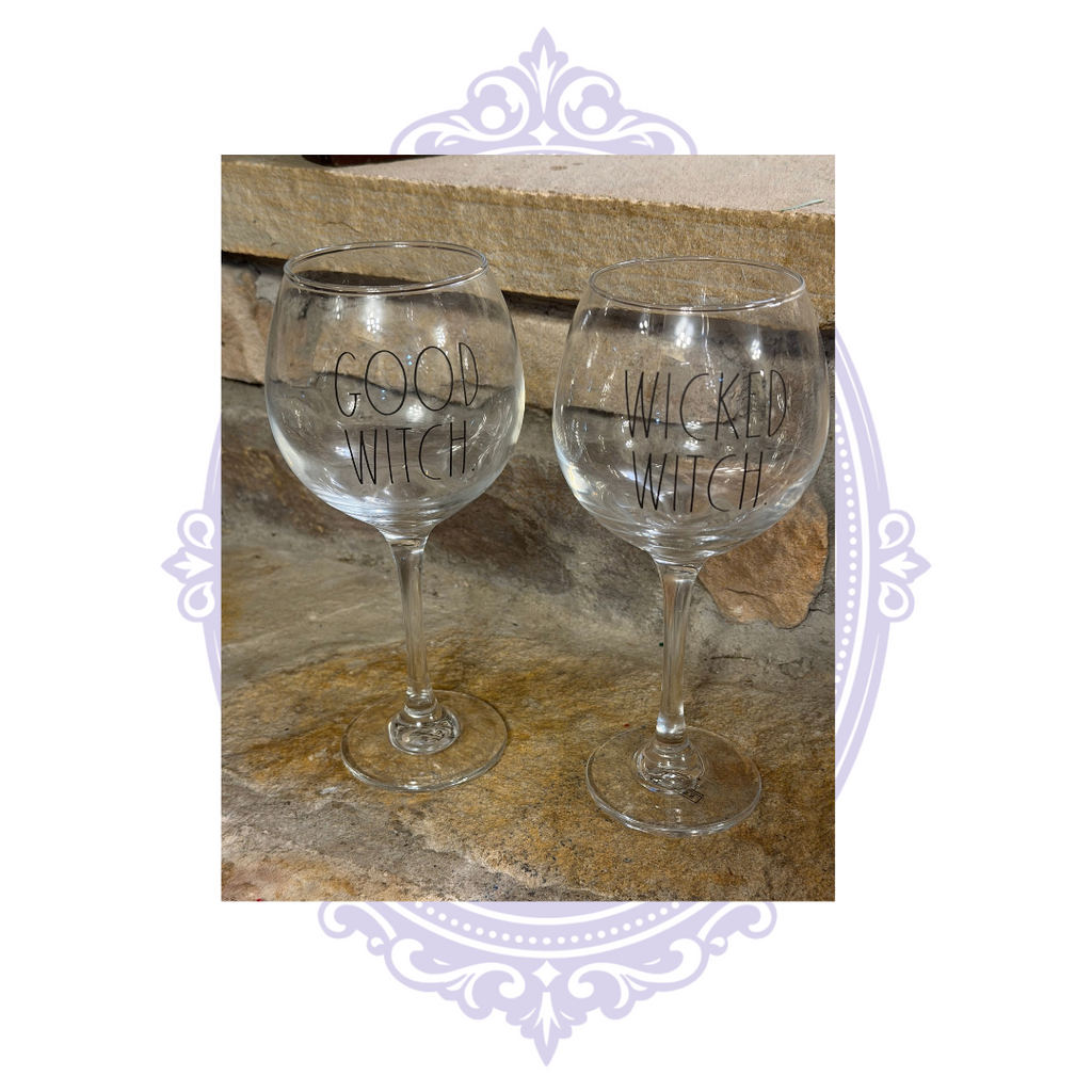 Pair of Rae Dunn Good Witch and Wicked Witch clear stemmed wine glasses