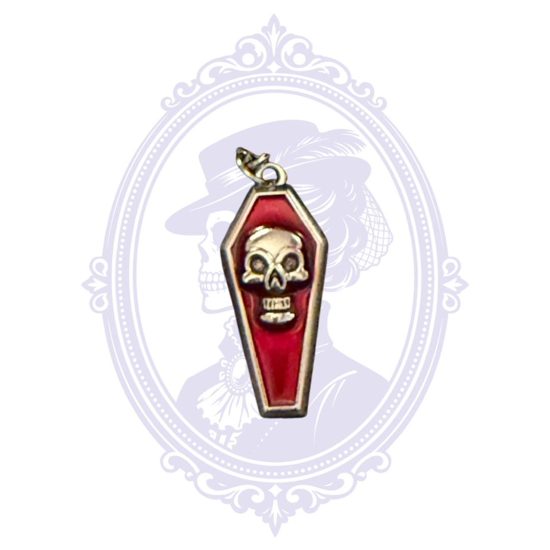 Close-up of red coffin pendant with raised silver-tone skull and silver-tone border.