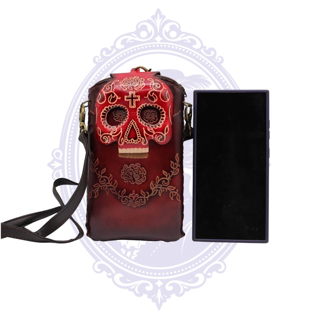 Red genuine leather sugar skull cell phone crossbody holder shown beside a card-sized object for scale.