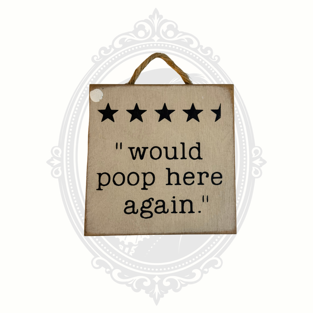 Rustic wooden hanging farmhouse sign with black stars and the phrase “would poop here again” on distressed cream painted wood