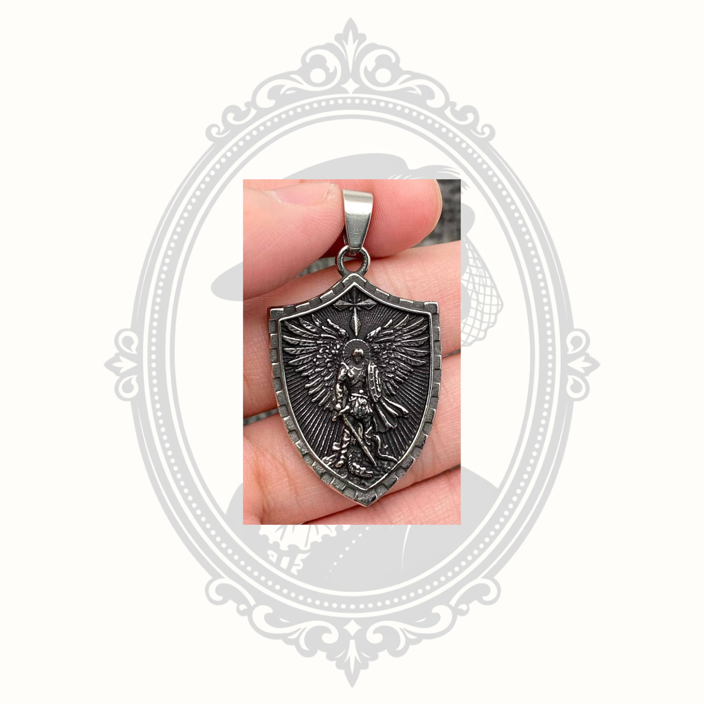 Saint Michael Archangel shield pendant displayed in hand showing the detailed front design.