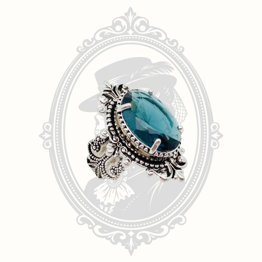 Sea blue goose egg-shaped glass ring with ornate vintage-inspired silver tone setting.