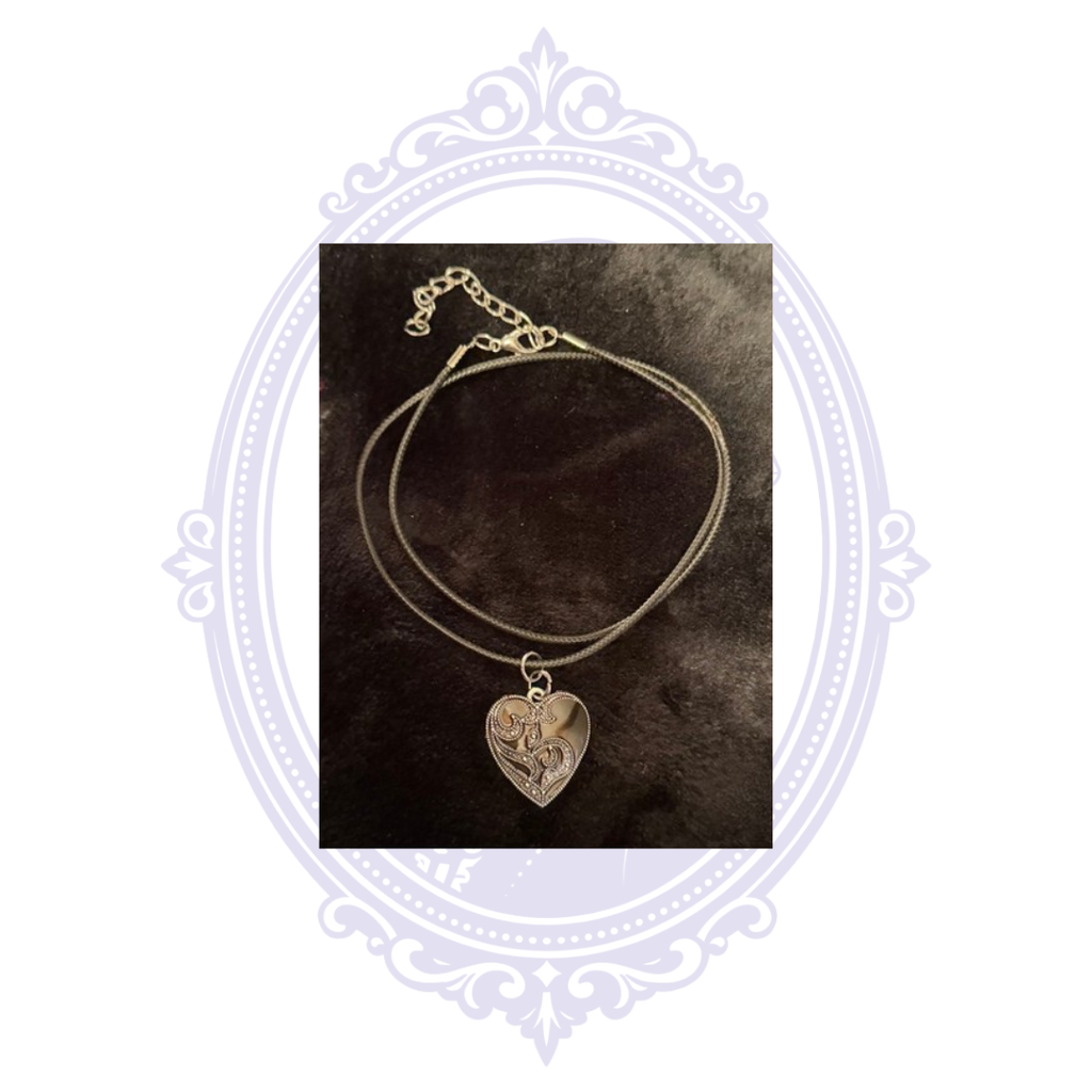 Silver-on-black ornate heart pendant necklace with black cord, lobster clasp and extender chain.