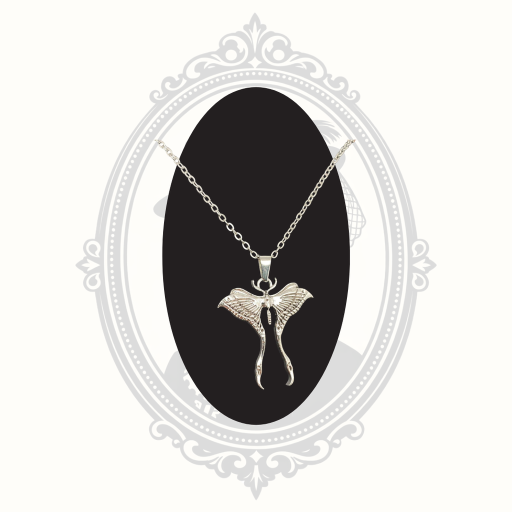 Silver-tone Luna moth pendant necklace displayed on a black circle.