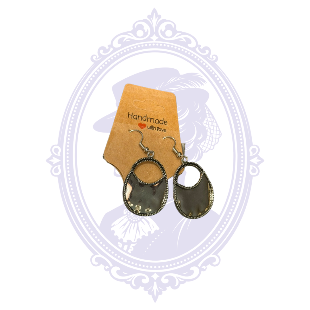Pair of silver-tone open oval dangle earrings with reflective hammered-look centers and textured metal borders.