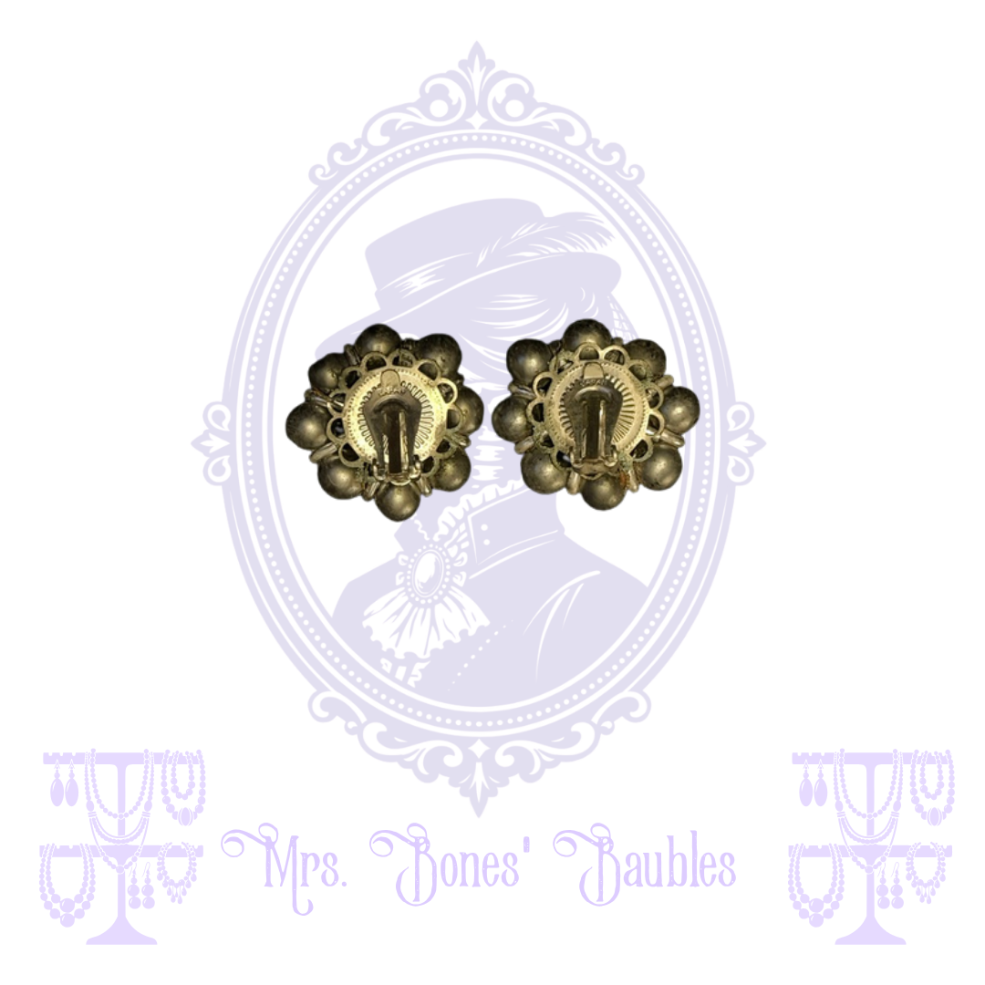 Back of silver-tone floral earrings showing hinged clip-on closures