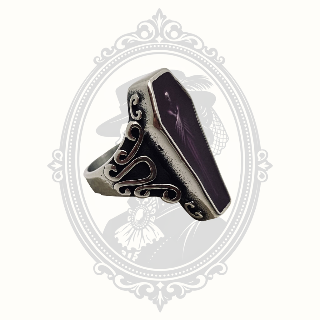 Angled view of the gothic coffin ring with purple zombie artwork.