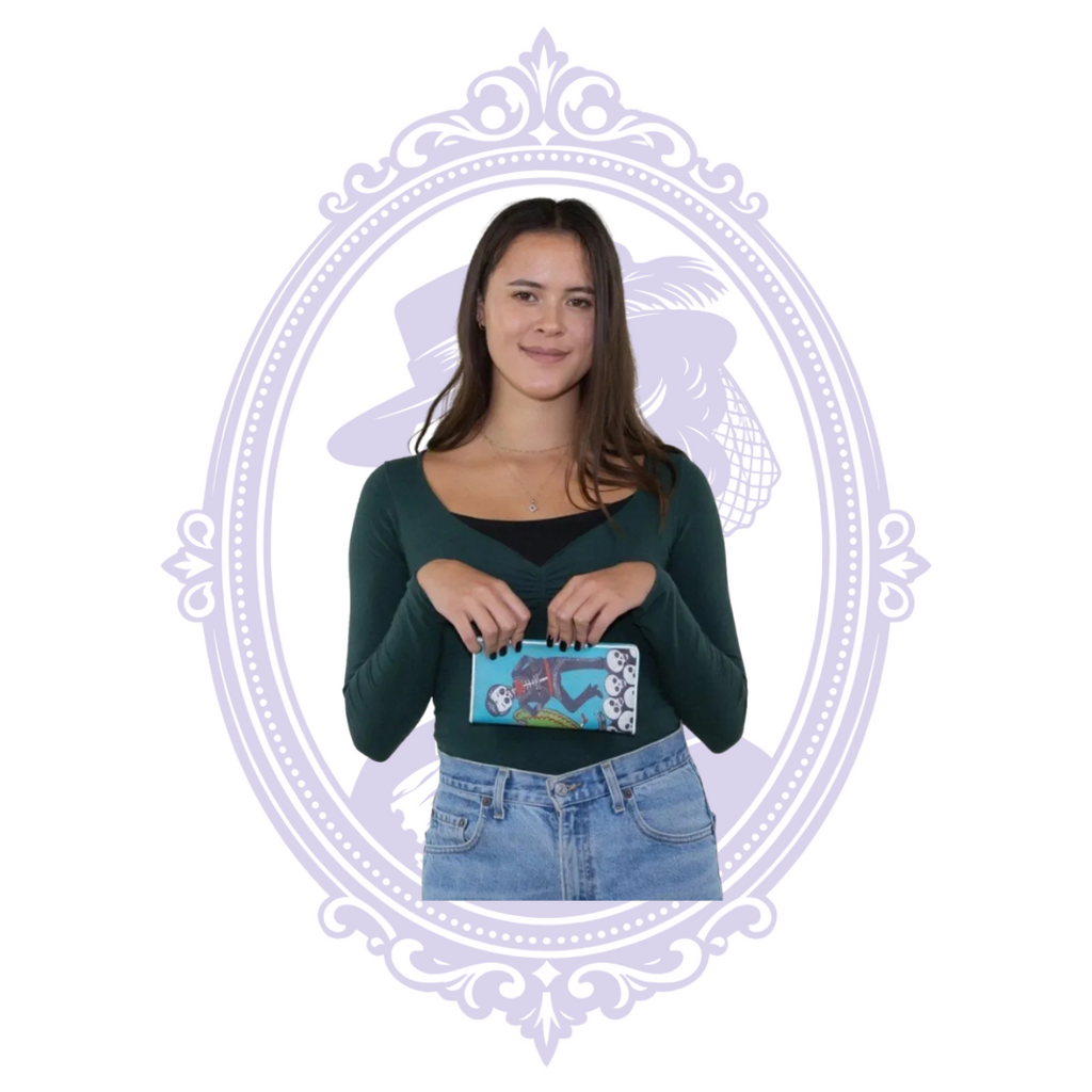 Model holding the turquoise sugar skull couple wallet horizontally, with skeleton artwork and skull border visible.