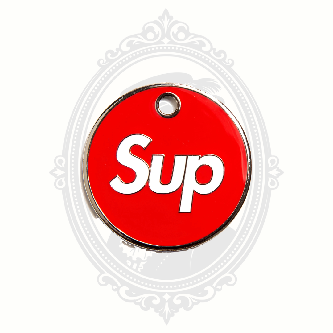 Red circular novelty pet tag featuring the word “Sup” in white lettering.