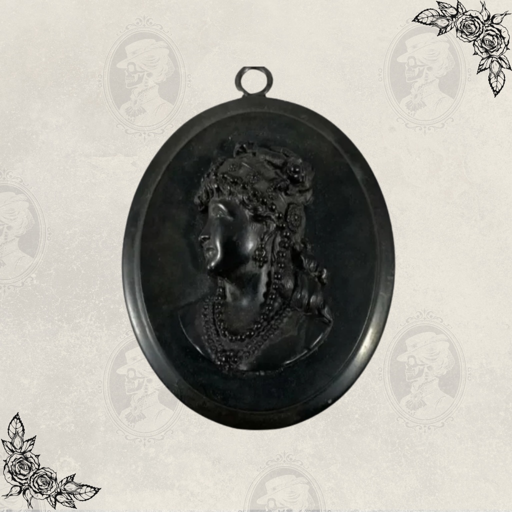 Full view of Victorian mourning cameo pendant with top loop for chain and oval black gutta percha frame