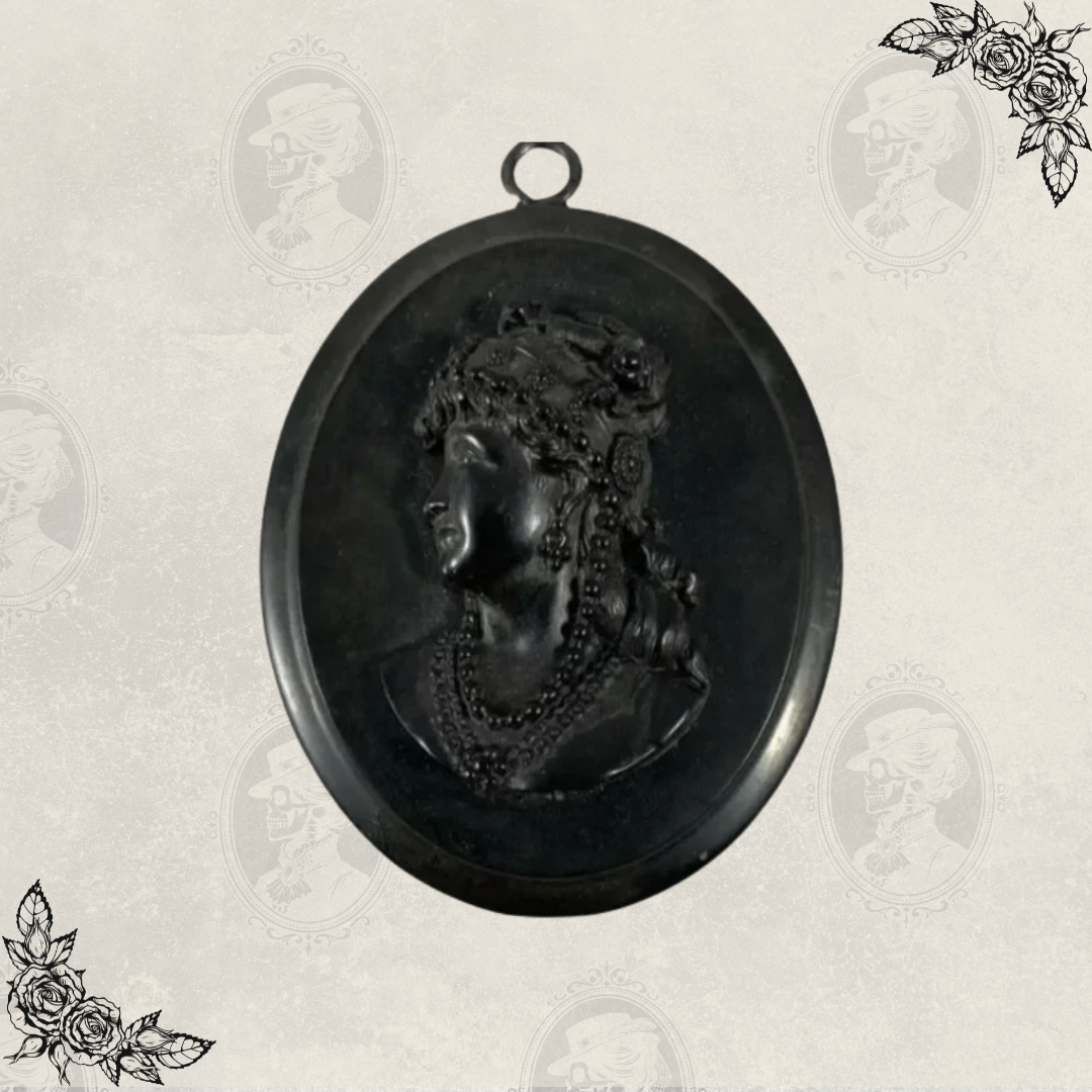 Full view of Victorian mourning cameo pendant with top loop for chain and oval black gutta percha frame