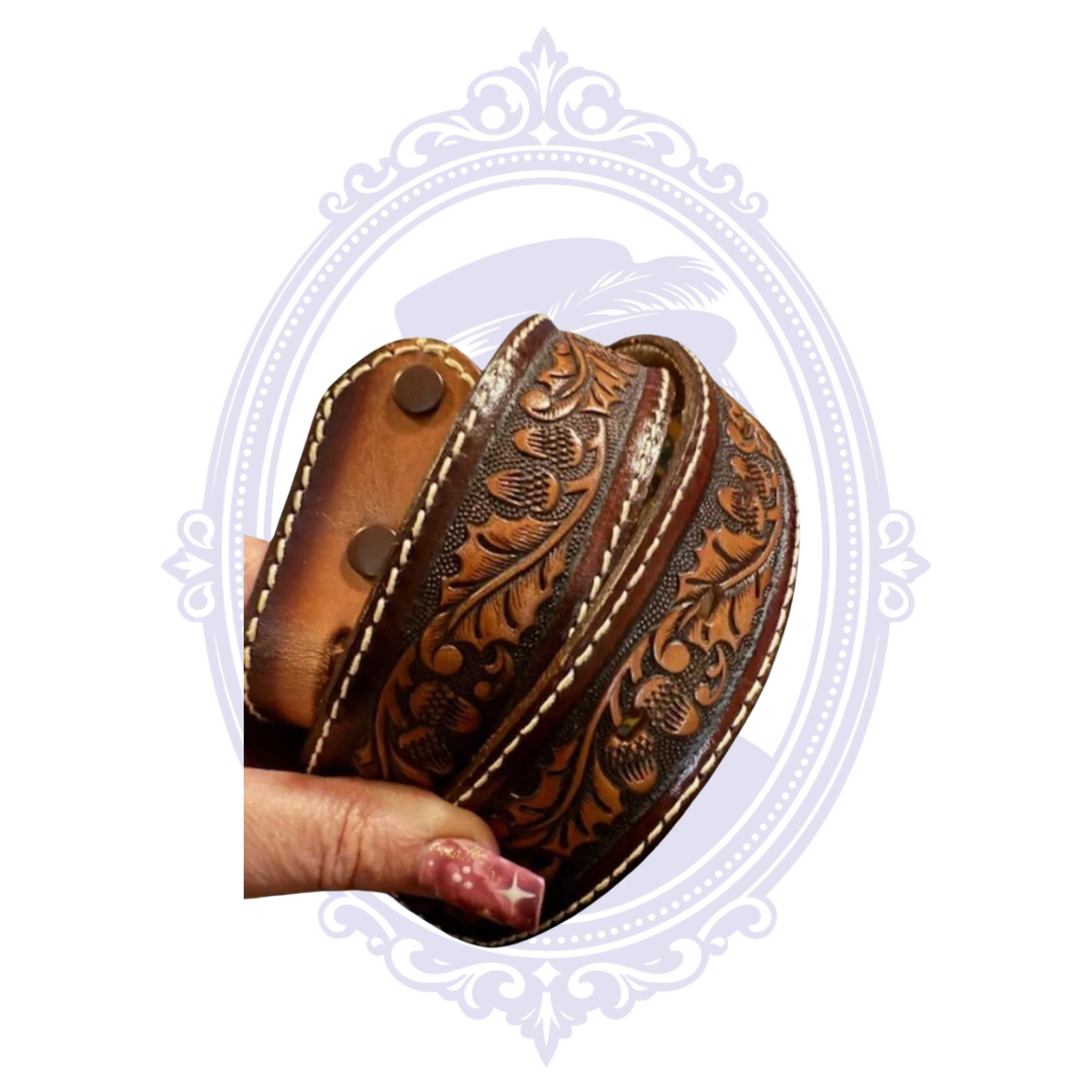 Vintage brown genuine leather belt with acorn and oak leaf tooling, contrasting cream stitching and snap-fastened buckle attachment.