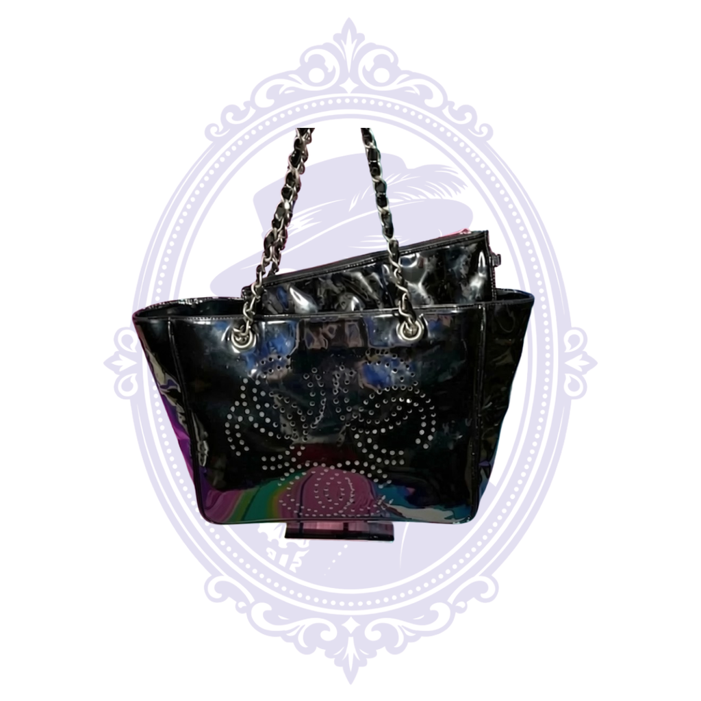 Vintage Chanel Triple Coco black patent leather chain tote shown on a stand with matching pouch inside.