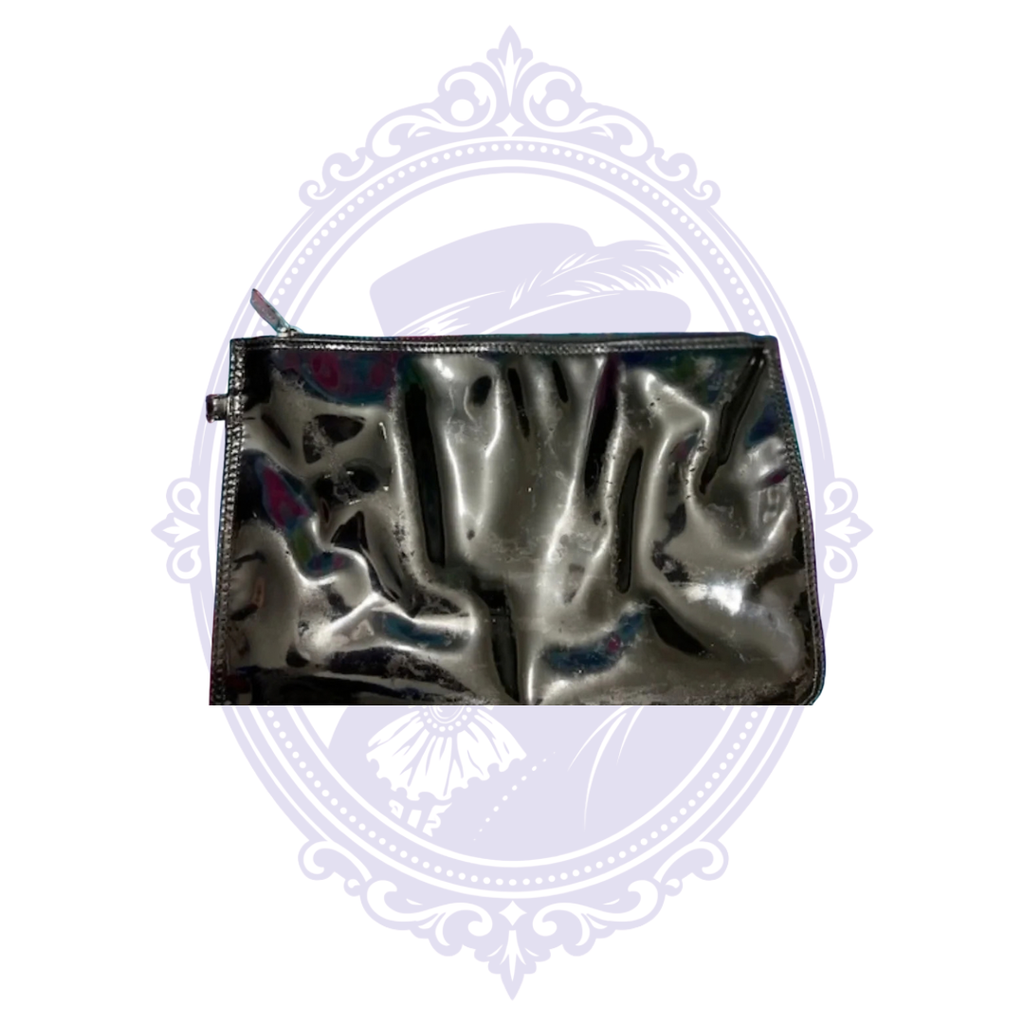 Close-up of black patent leather matching Chanel pouch showing surface condition and reflections.