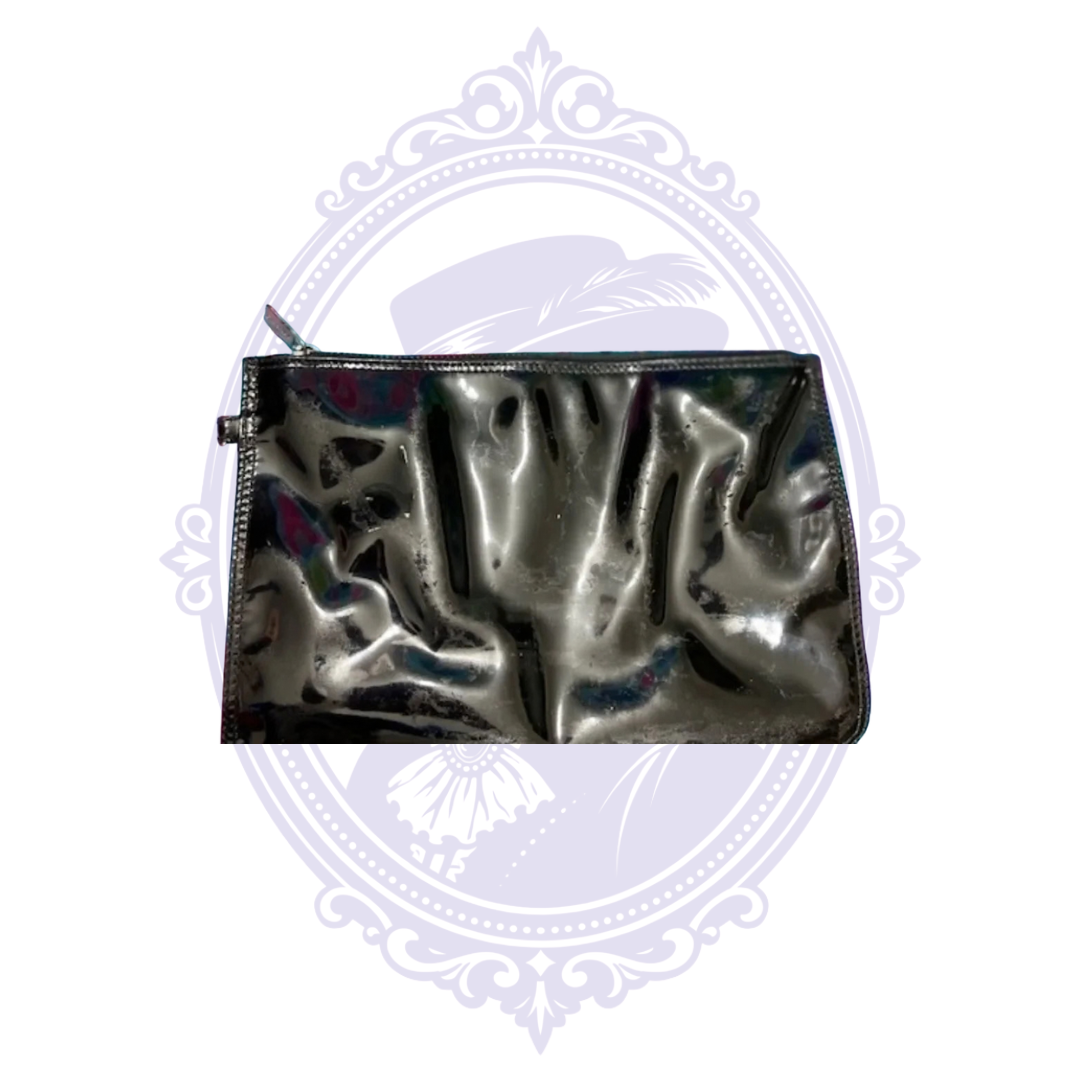 Close-up of black patent leather matching Chanel pouch showing surface condition and reflections.