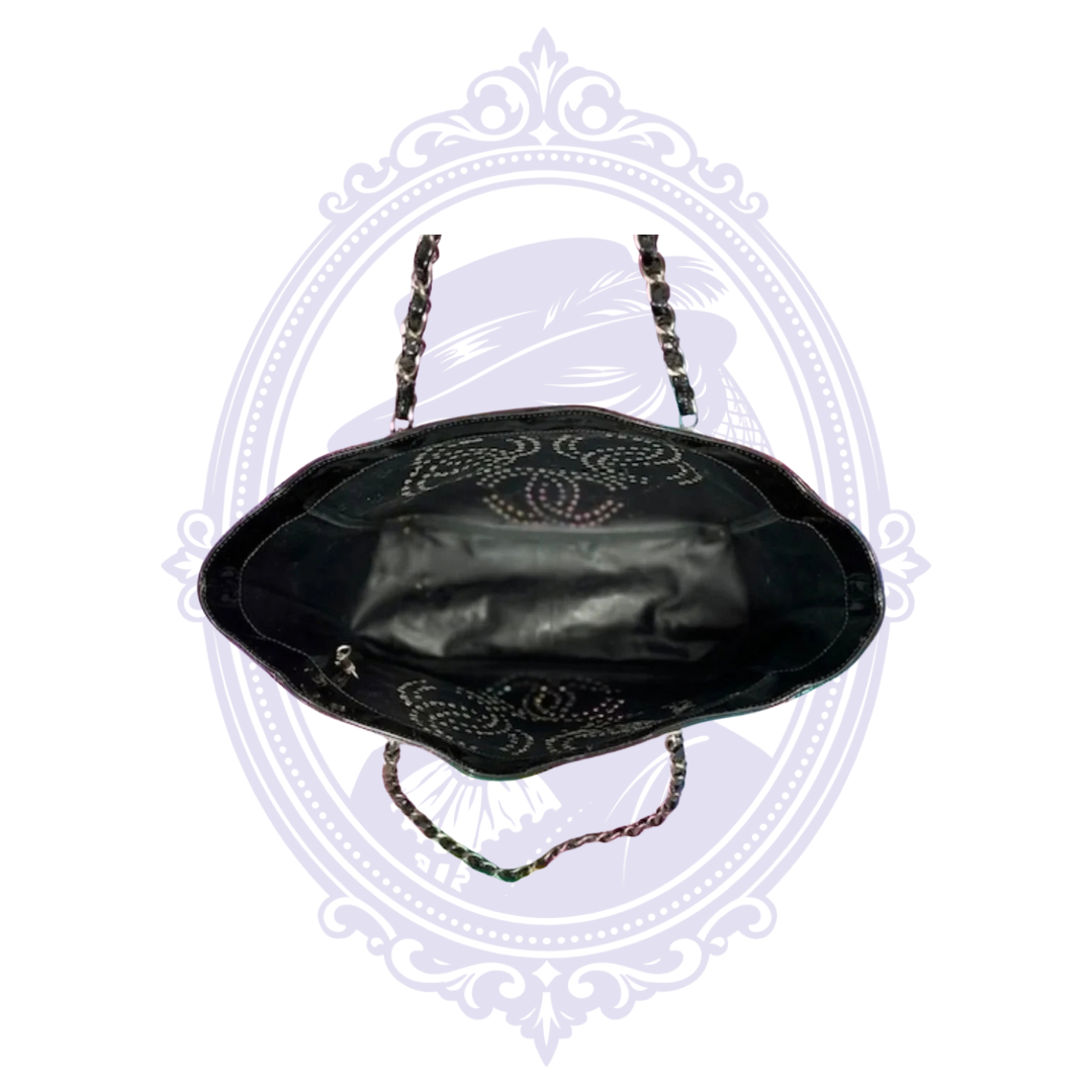 Interior view of vintage Chanel Triple Coco black patent leather tote showing lining and perforated CC details.