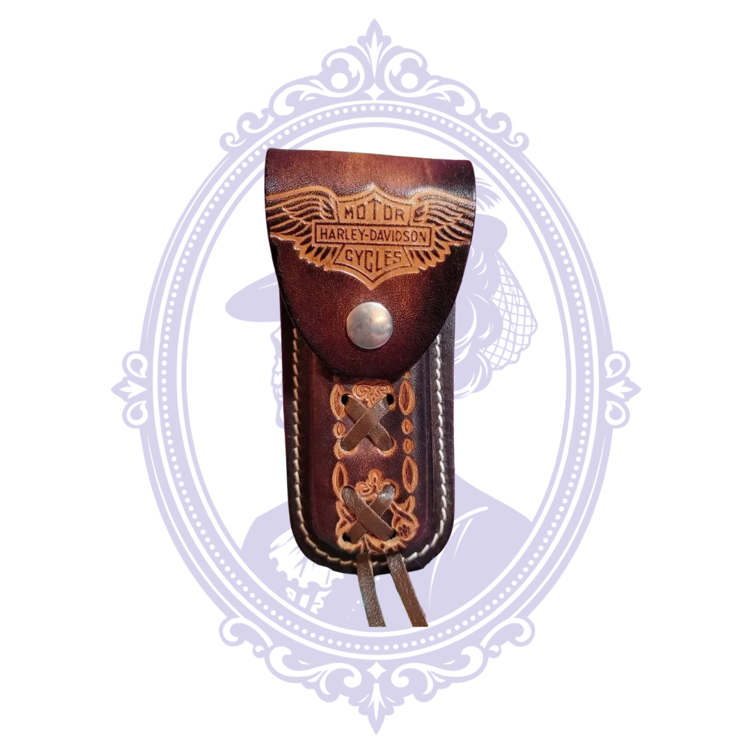 Front of vintage brown leather knife sheath with winged Harley-Davidson Bar and Shield design, snap closure and decorative lacing.