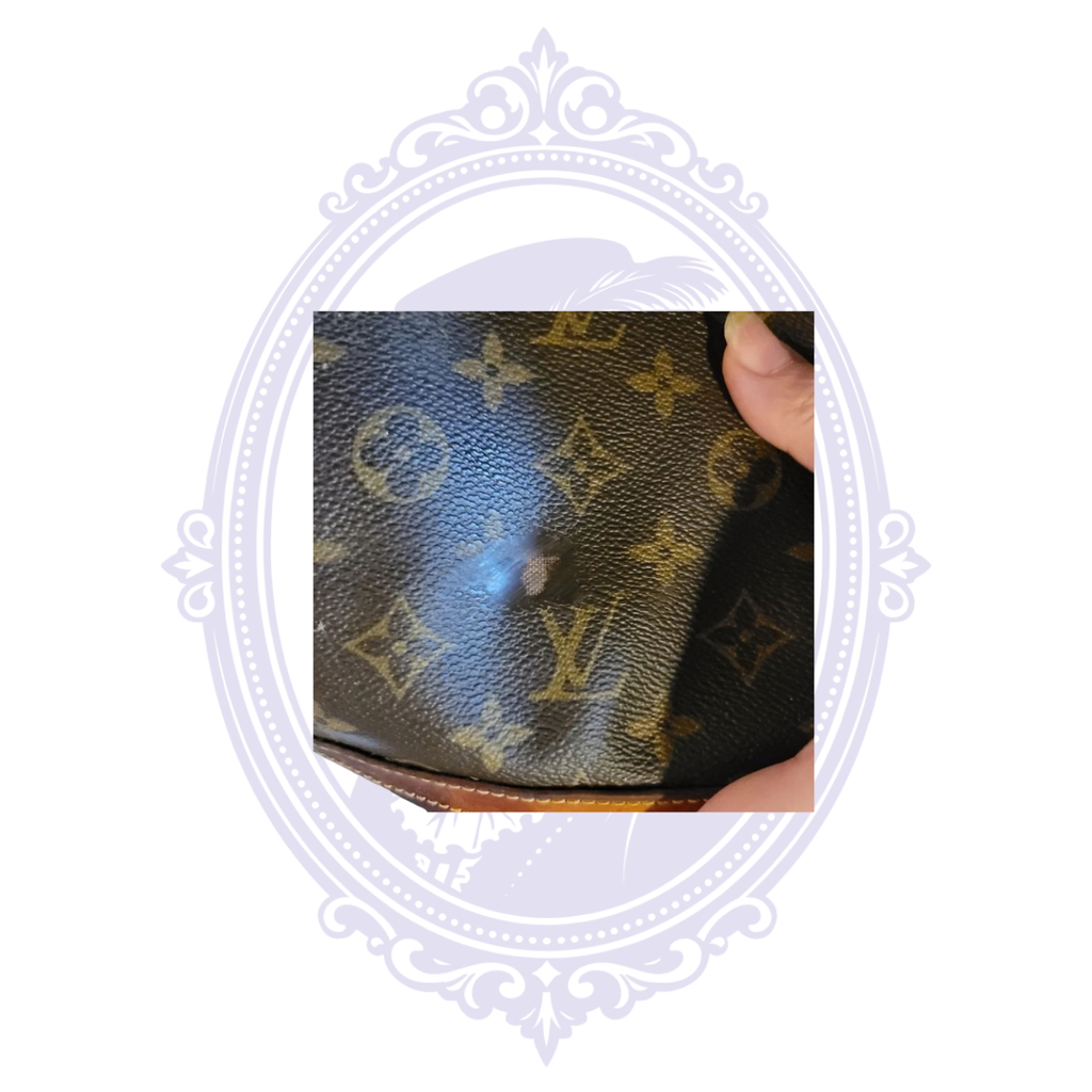 Close-up of vintage Louis Vuitton Petit Bucket PM monogram canvas showing a small rectangular area of surface discoloration or alteration.