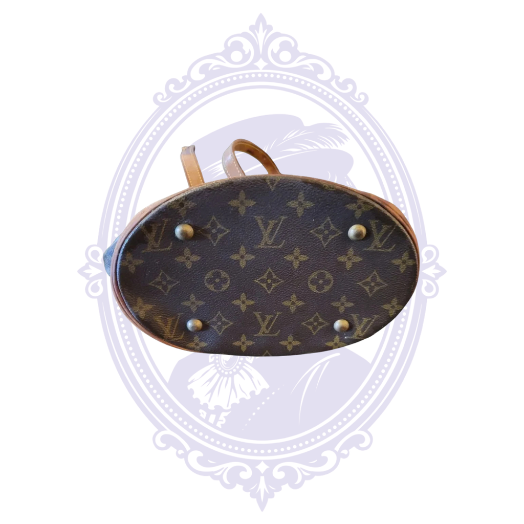 Bottom of vintage Louis Vuitton Petit Bucket PM showing monogram canvas, vachetta trim, and four protective feet.