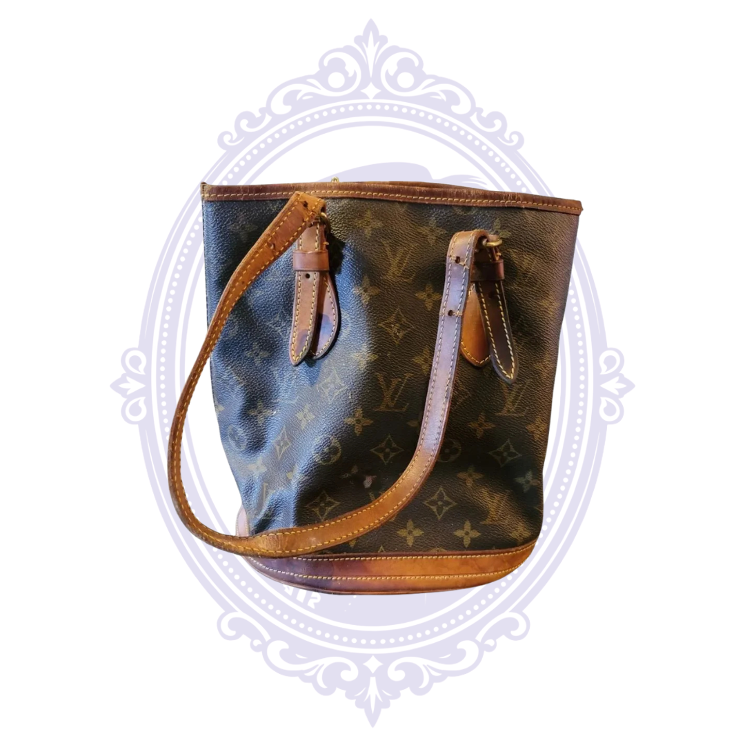 Front view of vintage 2001 Louis Vuitton Petit Bucket PM in monogram canvas with aged vachetta leather trim and shoulder straps.