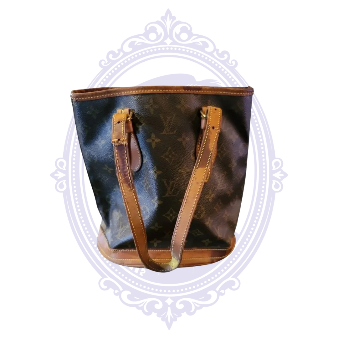 Rear view of vintage Louis Vuitton Petit Bucket PM showing monogram canvas and aged vachetta shoulder straps.