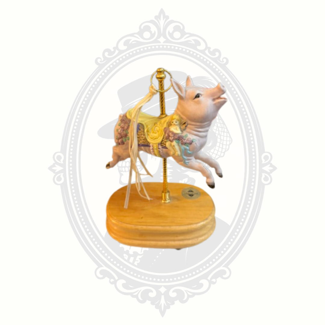 Side view of whimsical carousel pig collectible featuring ornate painted details and soft pastel tones.