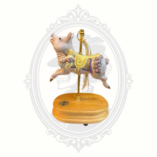 Vintage-style carousel pig collectible displayed with decorative saddle and intricate trim details.