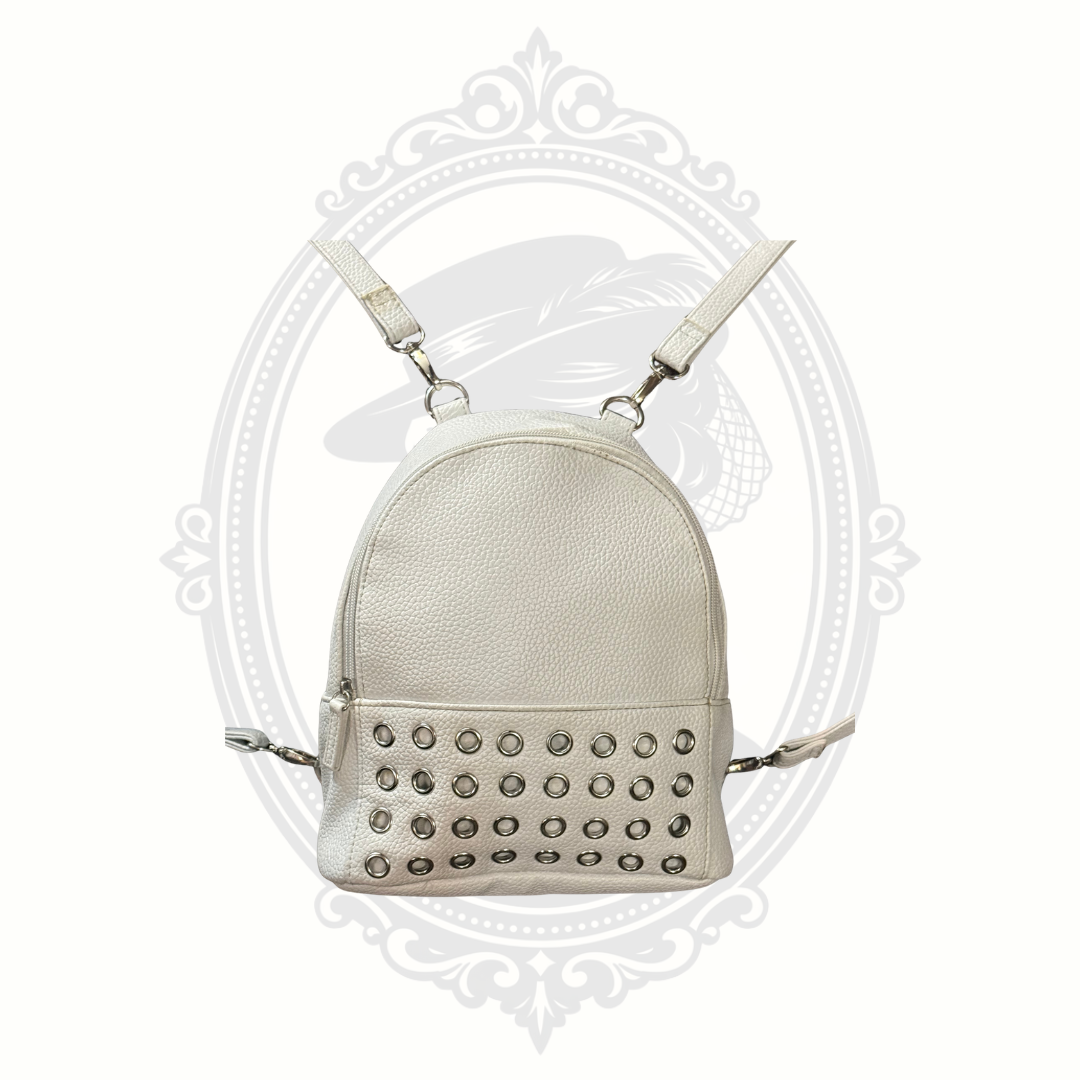 White mini backpack purse with silver grommet detailing and adjustable straps front view