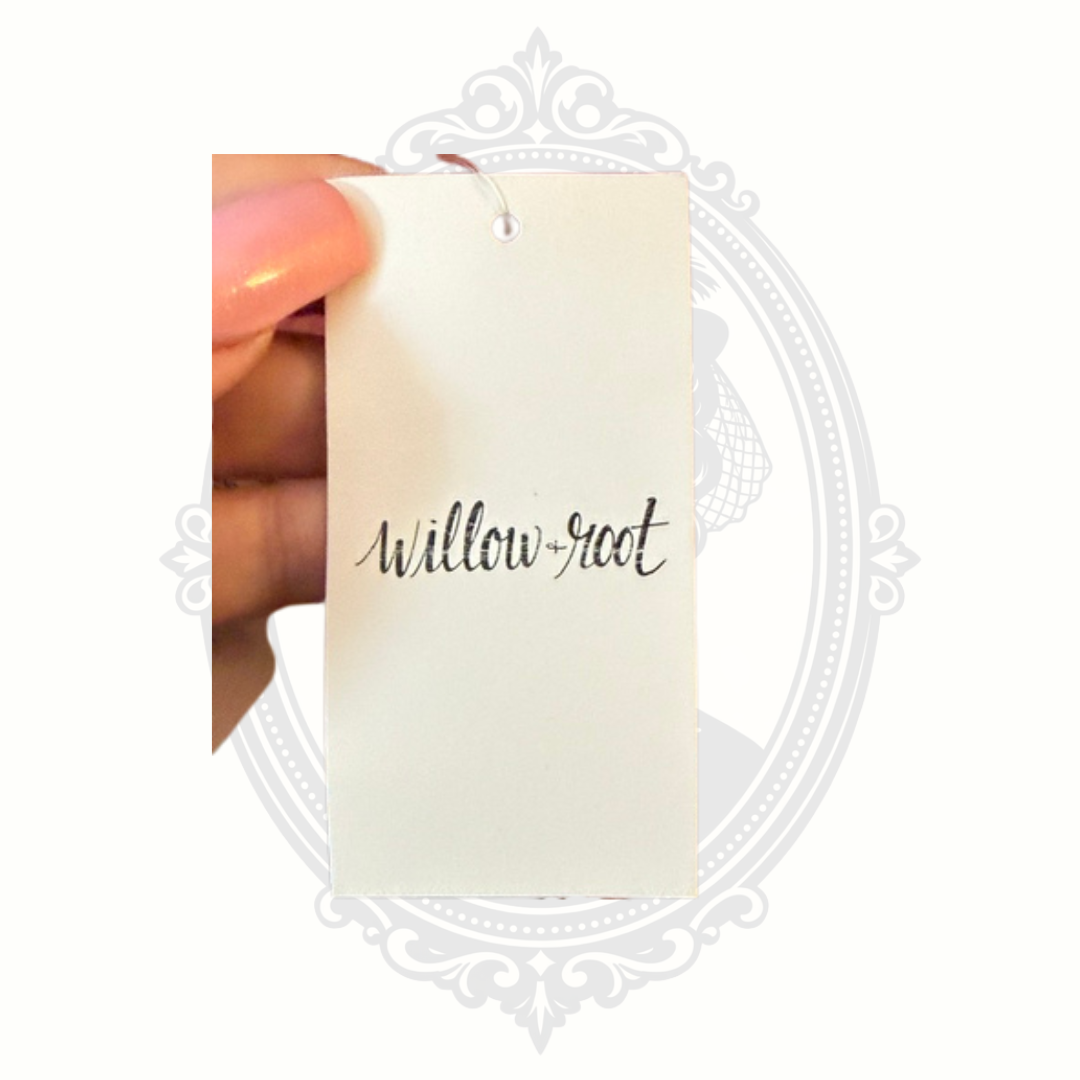 Hand holding a white card with 'Willow-root' text against a white background